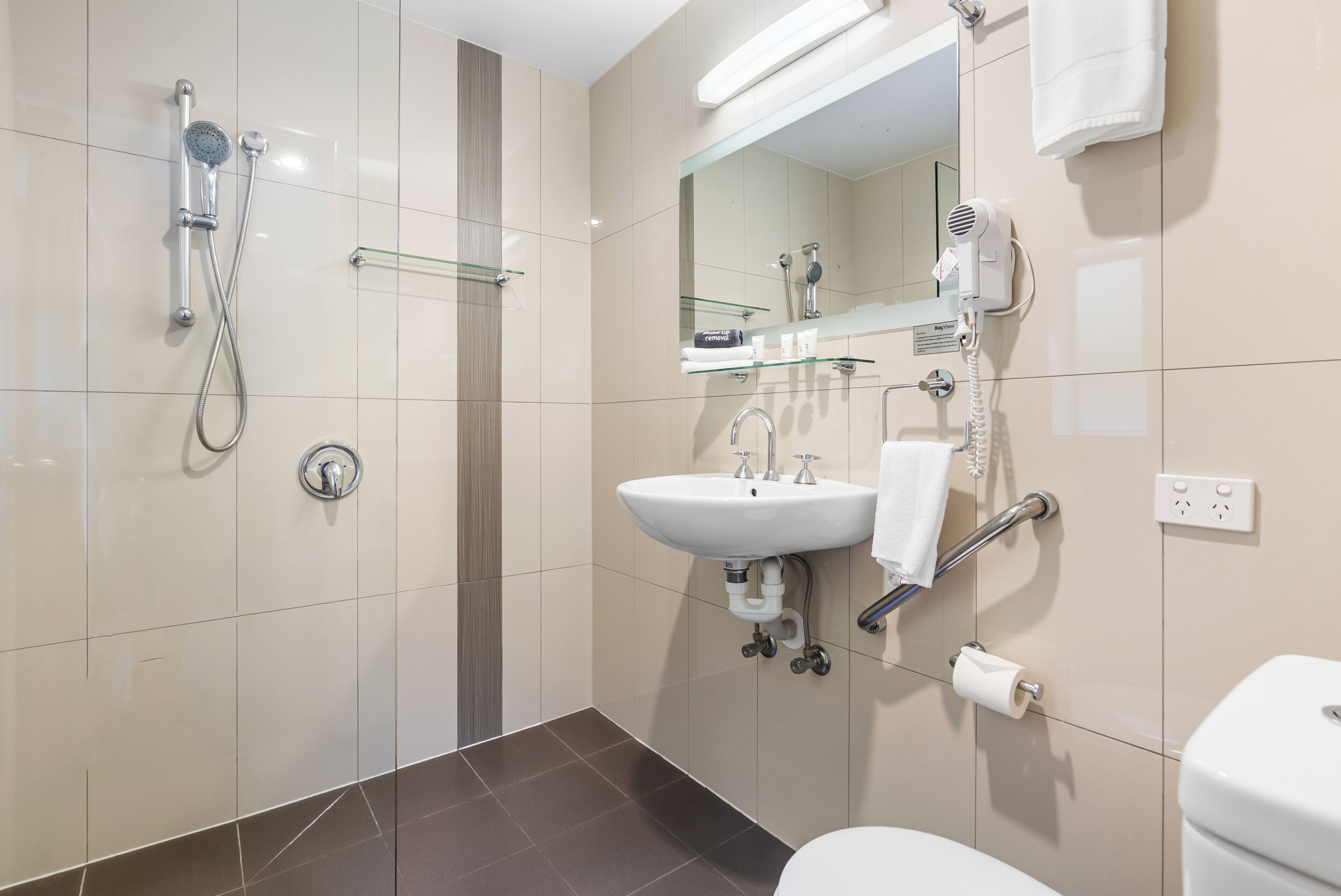 Une salle de bain moderne équipée d’une douche, d’un lavabo et de toilettes.