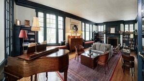 A spacious library with wooden furniture, large windows, and bookshelves. - The Dewey (Lenox)