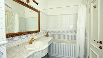 Luxe suite | Badkamer | Een bad, gratis toiletartikelen, een haardroger, pantoffels