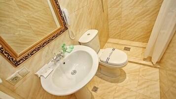 Un baño con lavamanos, inodoro y ducha.