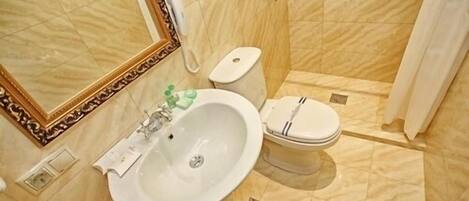 Un baño con lavamanos, inodoro y ducha.