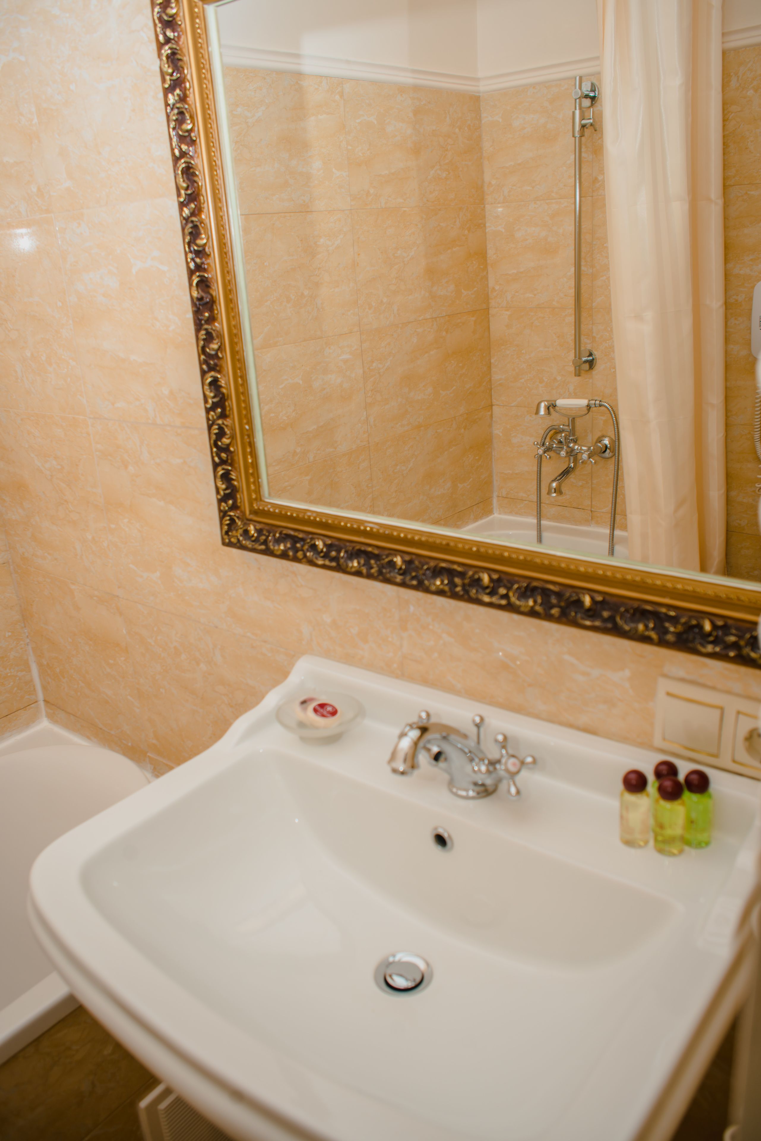 Un baño con un espejo grande, un lavamanos y una ducha.