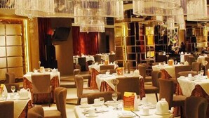A restaurant with multiple tables set for dining, each with white tablecloths and chairs. - Guangdong Jin Bao Lai Hotel (Guangzhou)