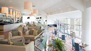 A spacious lobby with a bar area, seating arrangements, and large windows providing natural light. - Lakeside Park Hotel & Spa (Ryde)