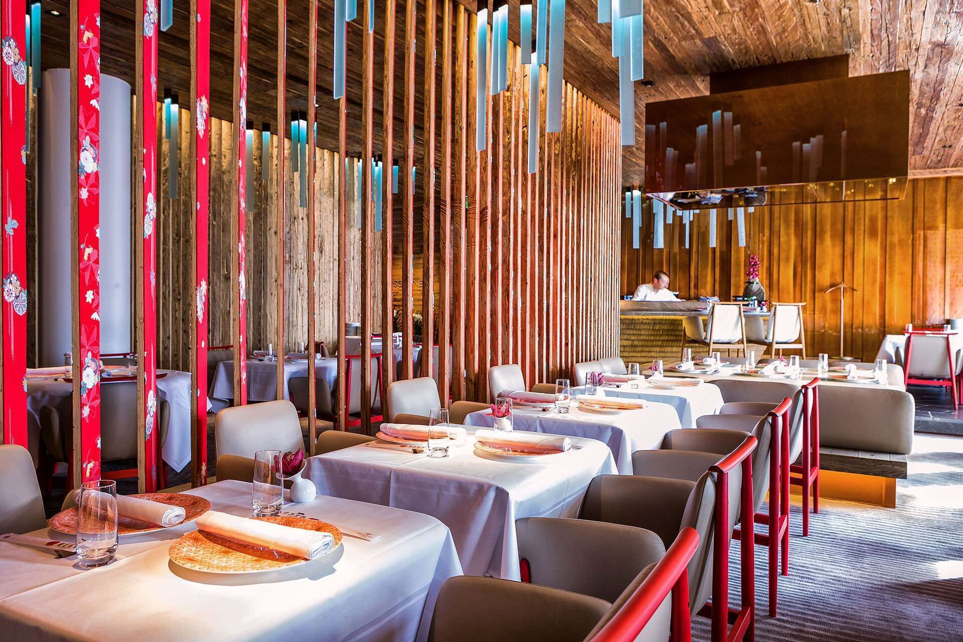 A restaurant with multiple tables, each set with plates, glasses, and cutlery.