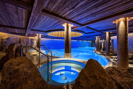 Indoor pool, outdoor pool, pool umbrellas, pool loungers. The Alpina Gstaad