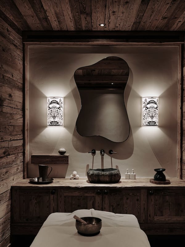 Experience serenity in this minimalist bathroom with a wooden ceiling, curved mirror, and soft lighting.