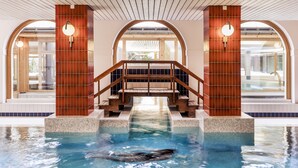 Piscina con cubierta de madera y escaleras que llevan a un área techada.