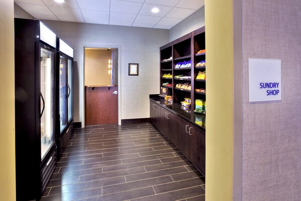 A corridor with a refrigerated display, a snack shop, and a door leading to another room.
