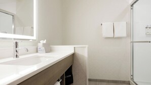 A modern bathroom with a large mirror, a sink, and a shower area. - Holiday Inn Express & Suites Oak Ridge by IHG (Oak Ridge)