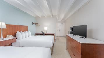 Una habitación de hotel con dos camas, un escritorio con silla, un televisor y un aparador.
