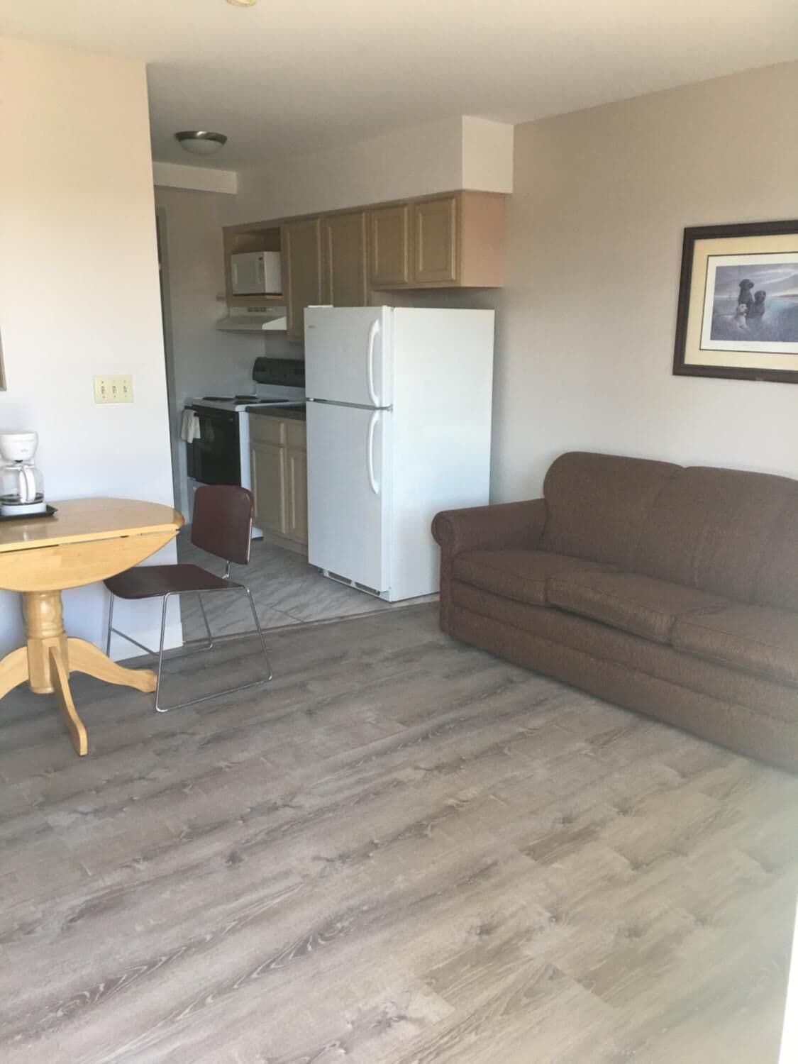 Un espacio habitable compacto con kitchenette, comedor y sofá.
