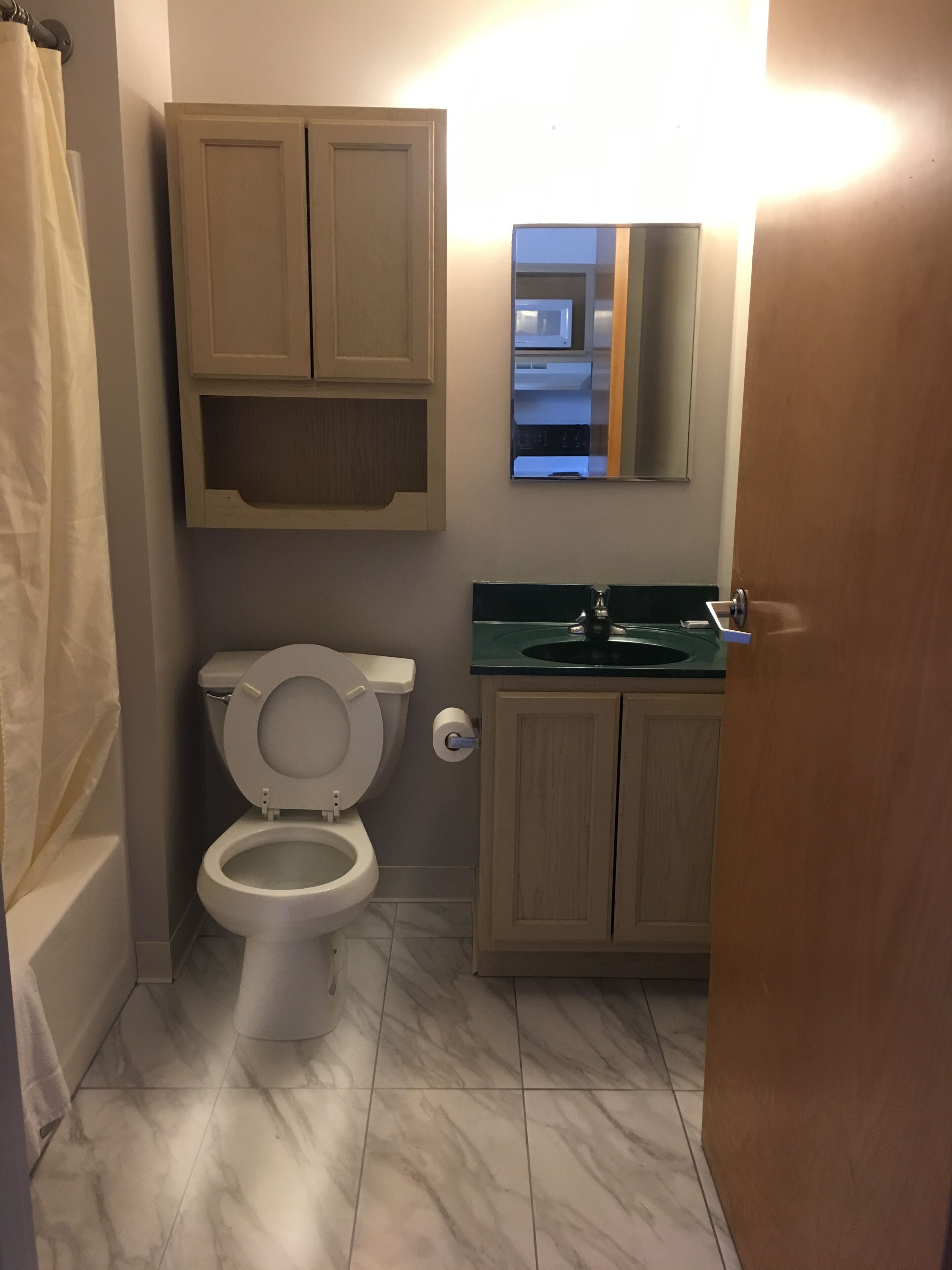 Une salle de bain avec des toilettes, un lavabo et un meuble de rangement.
