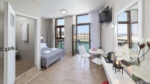 A modern hotel room with a balcony, a bed, a desk, and a TV. - Faros Beach Hotel (Rethymno)