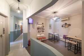 Um interior moderno com um corredor que leva a uma sala de jantar, uma televisão e um extintor de incêndio.