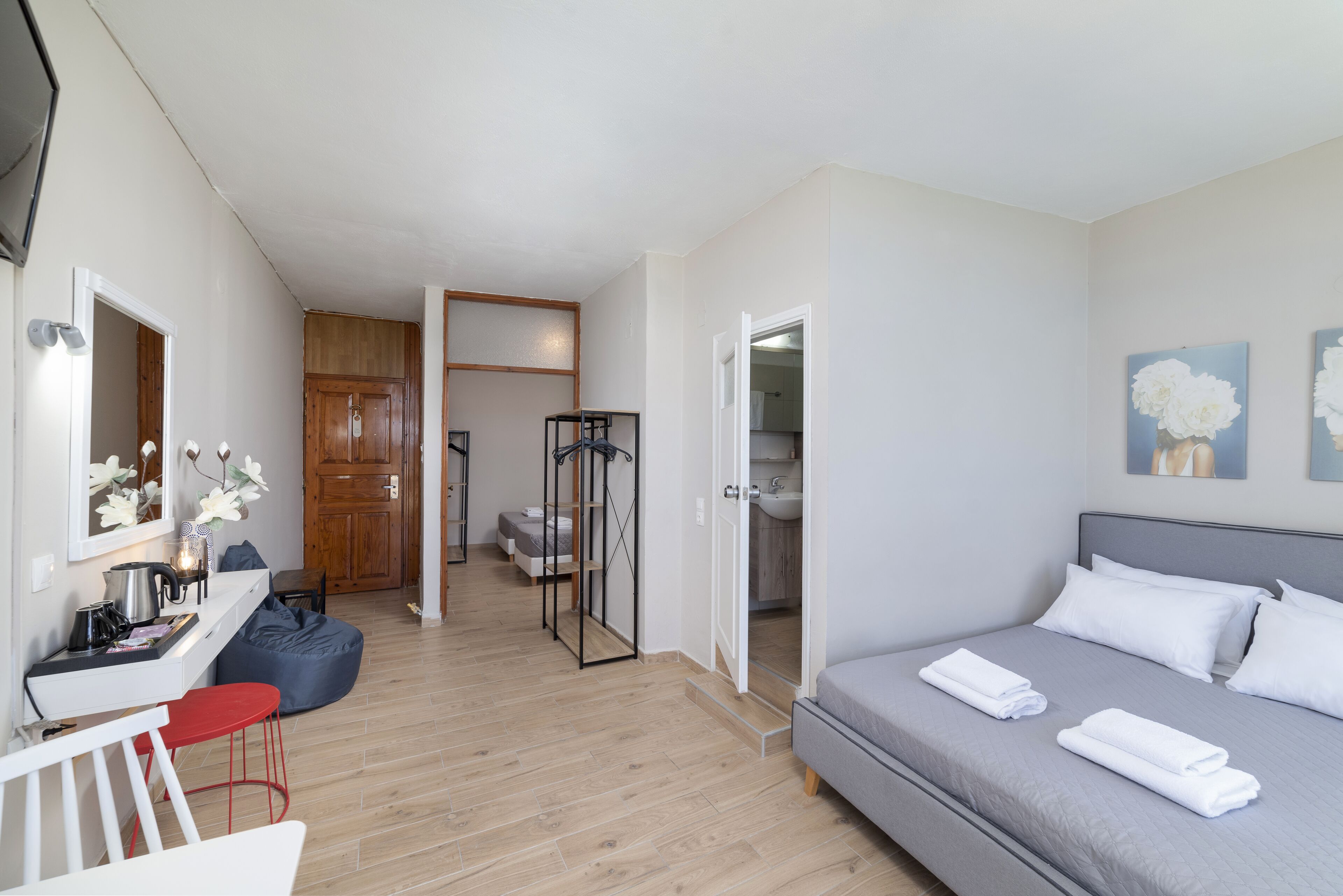Ein modernes Schlafzimmer mit einem Bett, einem Nachttisch und einem Schreibtisch mit Stuhl.