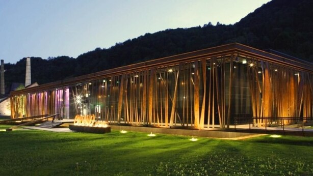 Un edificio moderno con fachada de vidrio y una serie de listones verticales de madera.