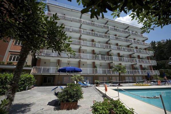 A multi-story hotel with balconies, a swimming pool, and outdoor seating areas. - Angelina Residence (Maiori)