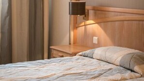 A hotel room with a bed, a nightstand, a lamp, and a window with curtains. - Hôtel Beau Rivage, Restaurant L'Eveil des Sens (Le Vivier-sur-Mer)