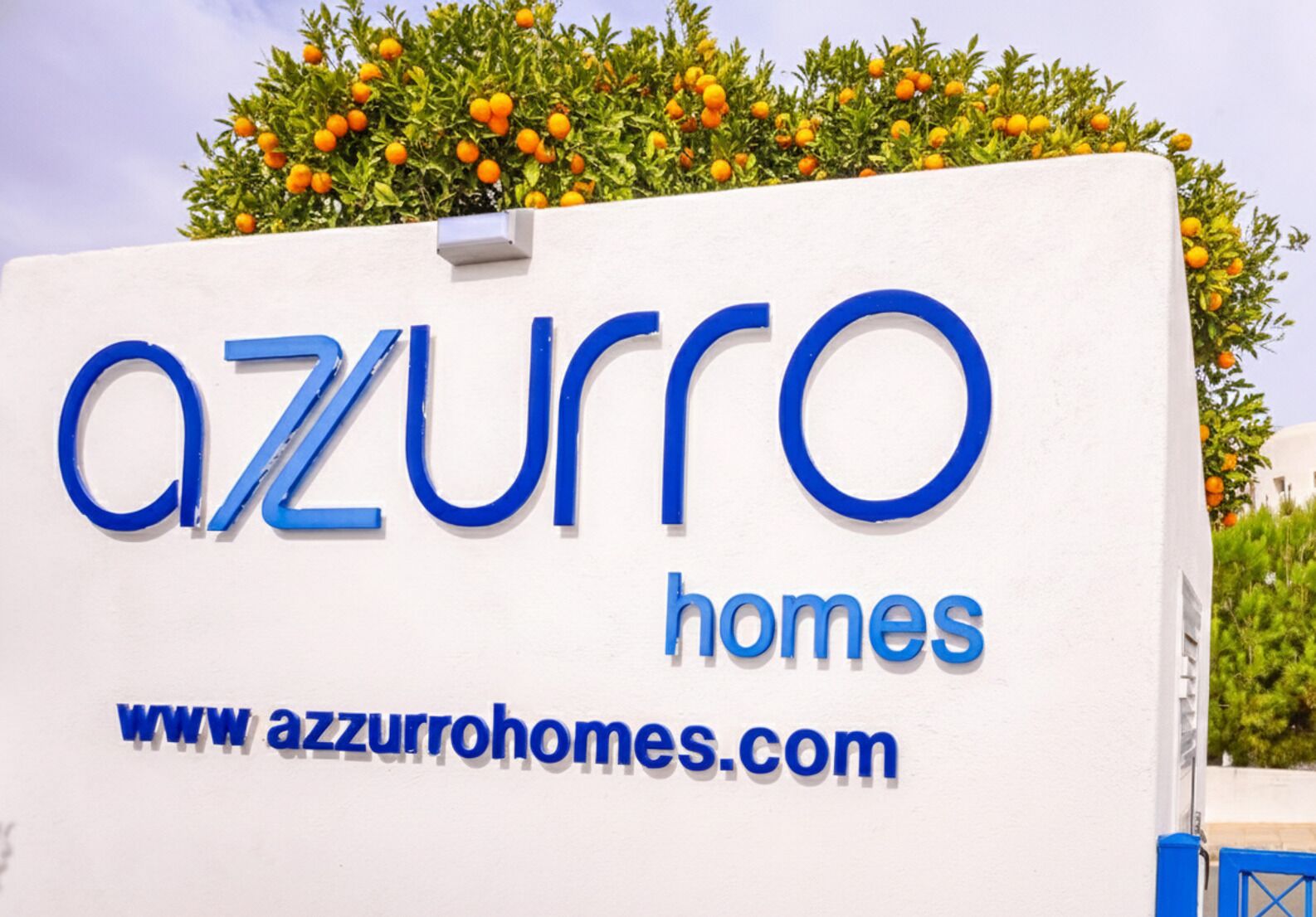 A sign for azzuro homes with a website address.