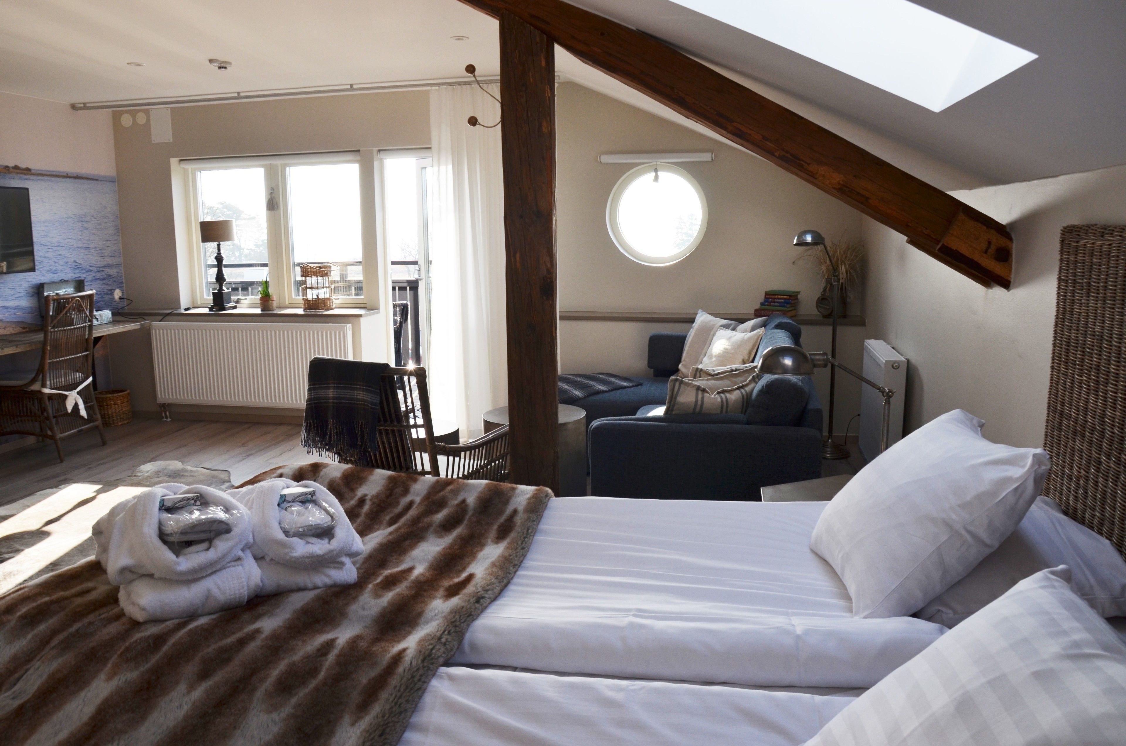 Una habitación acogedora con una cama, una silla, una mesa y una ventana.