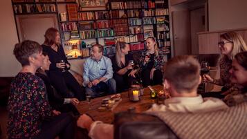 A group of people sitting around a wooden table in a room with bookshelves filled with books.