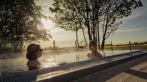 Un bain à remous avec vue sur les arbres et un coucher de soleil.