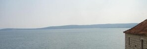 A coastal building with a tiled roof overlooking a calm sea. - XIV Century rooms (Kastela)