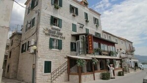 A stone building with a sign reading "Hotel Rooms." - XIV Century rooms (Kastela)
