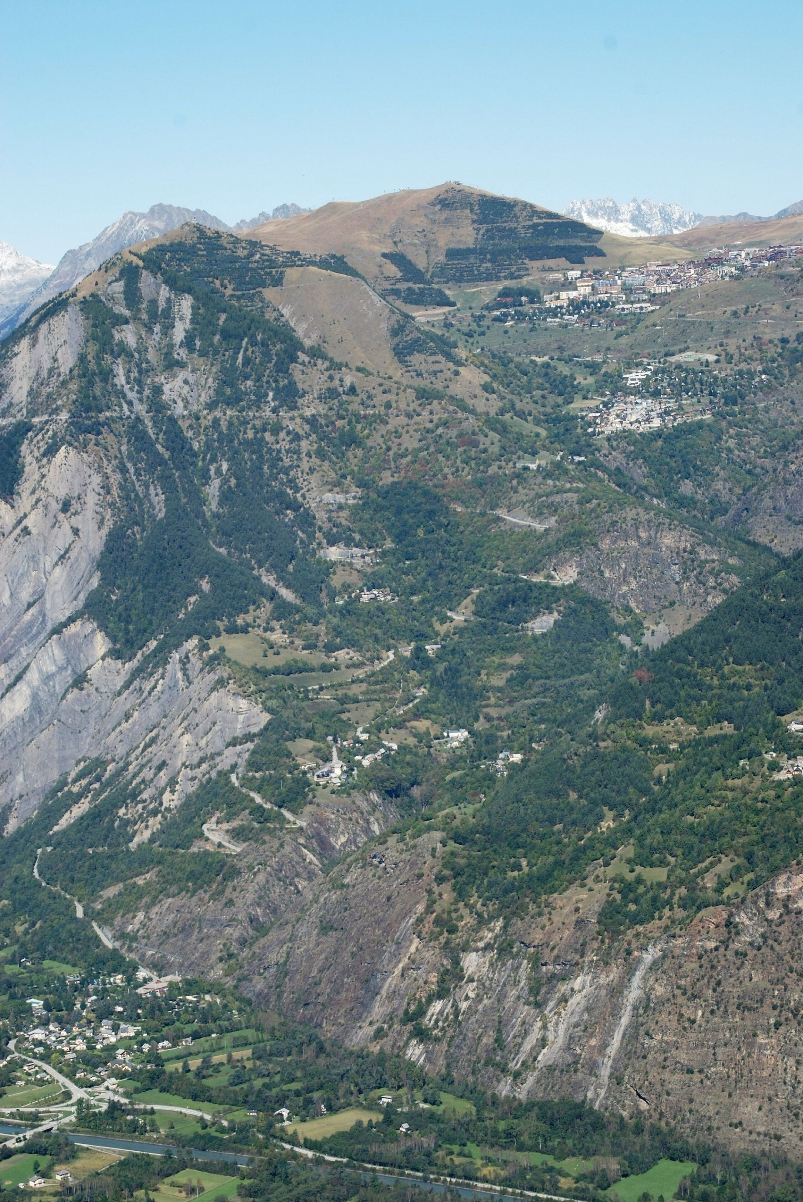 Un paysage montagneux avec une ville nichée au fond de la vallée.