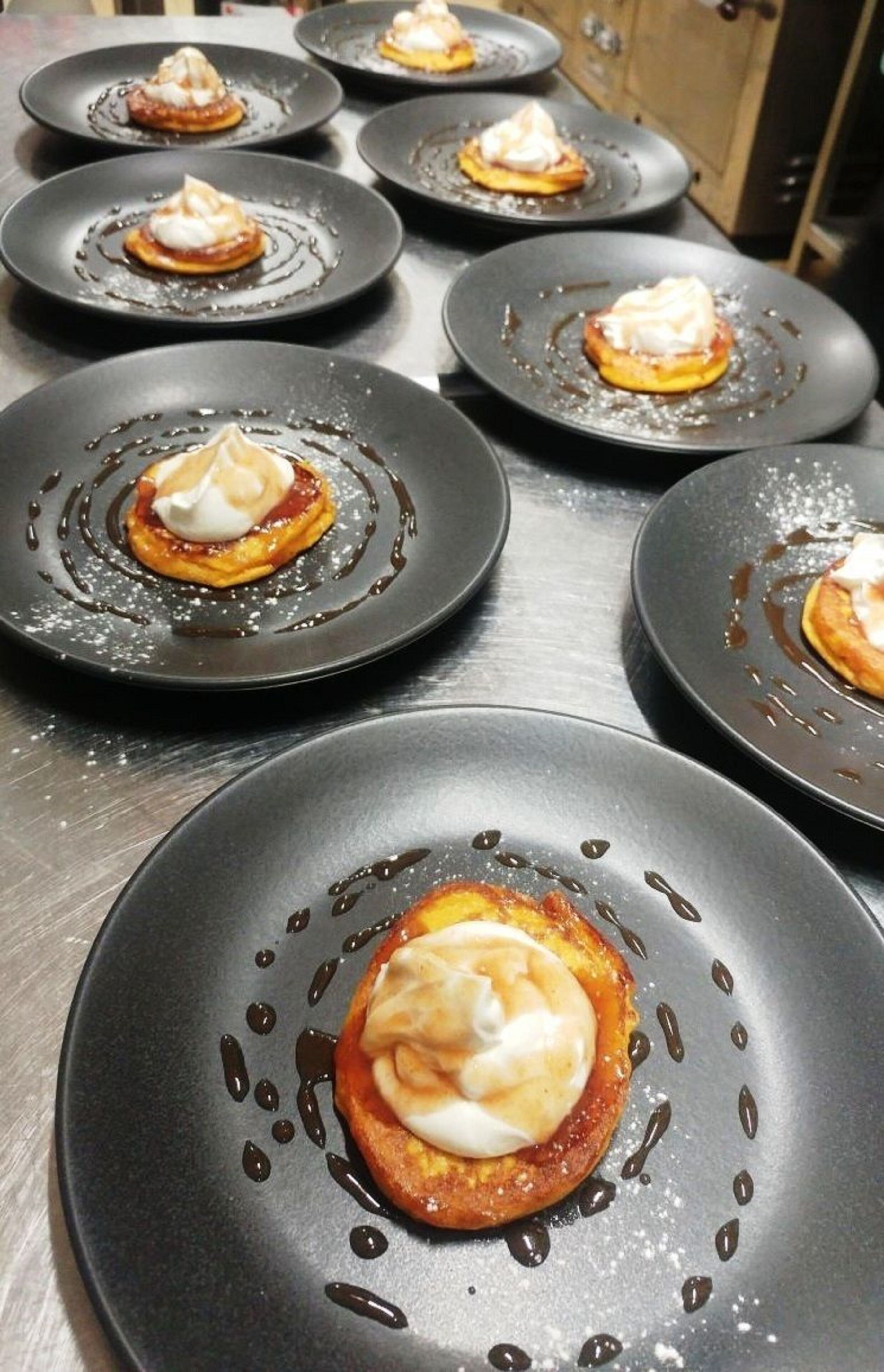 Una serie di piatti con dolci su un tavolo in acciaio inox.