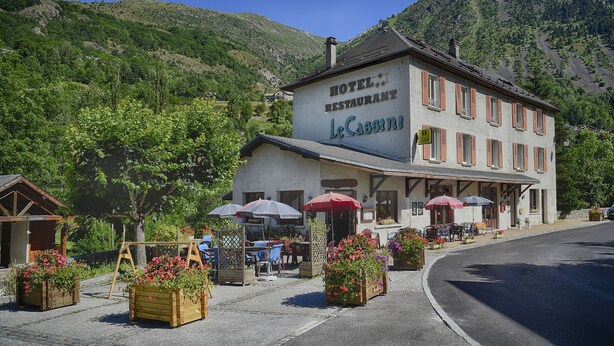 A hotel with outdoor seating and flower planters.