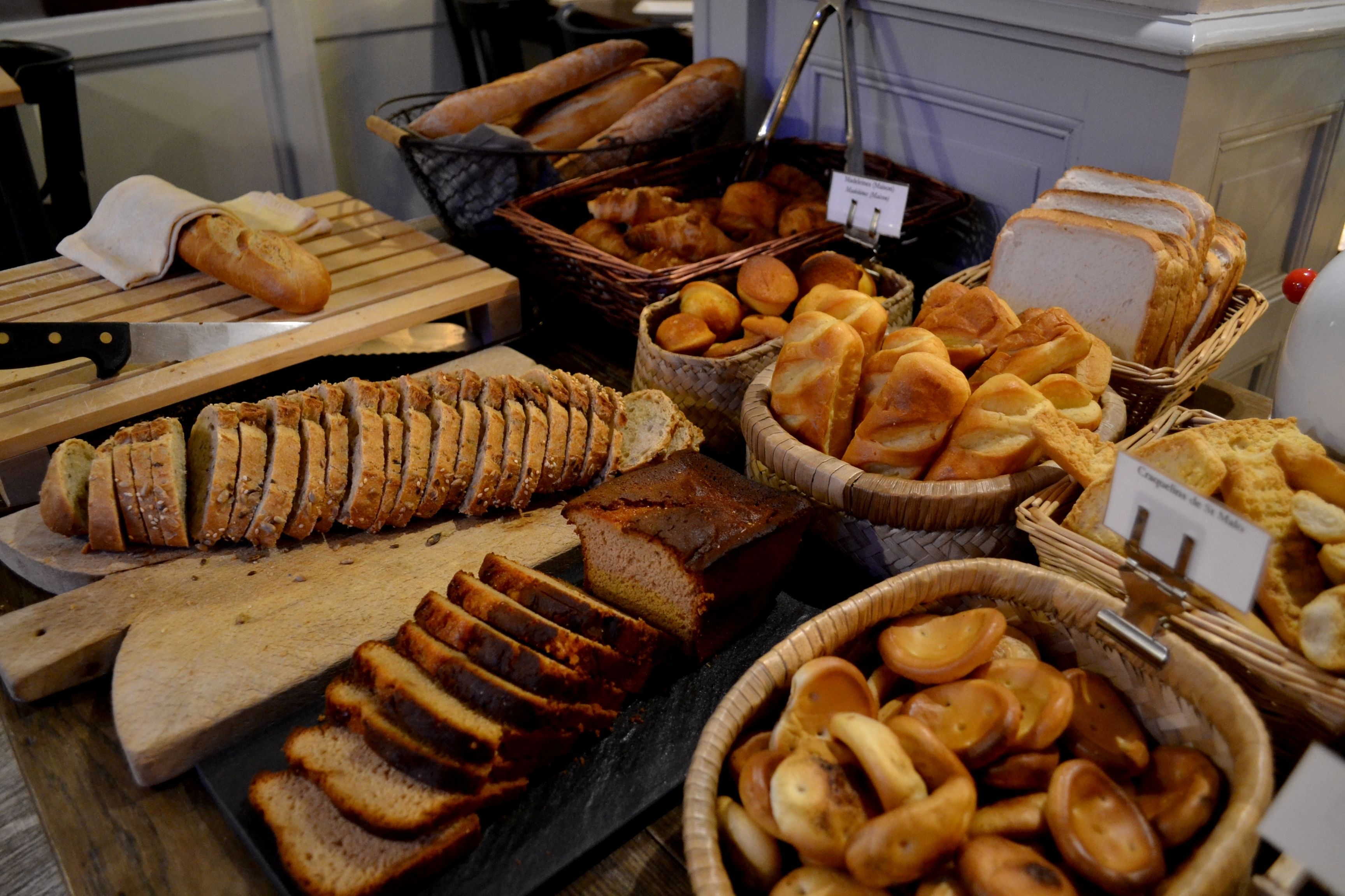 Diverse broden en gebak gepresenteerd op houten planken en manden.