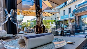 An outdoor dining area with tables, chairs, and umbrellas. - Hotel Du Parc (Perros-Guirec)
