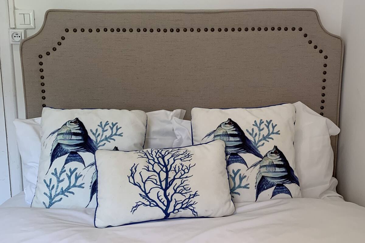 A bed with a headboard featuring a decorative border of round buttons.