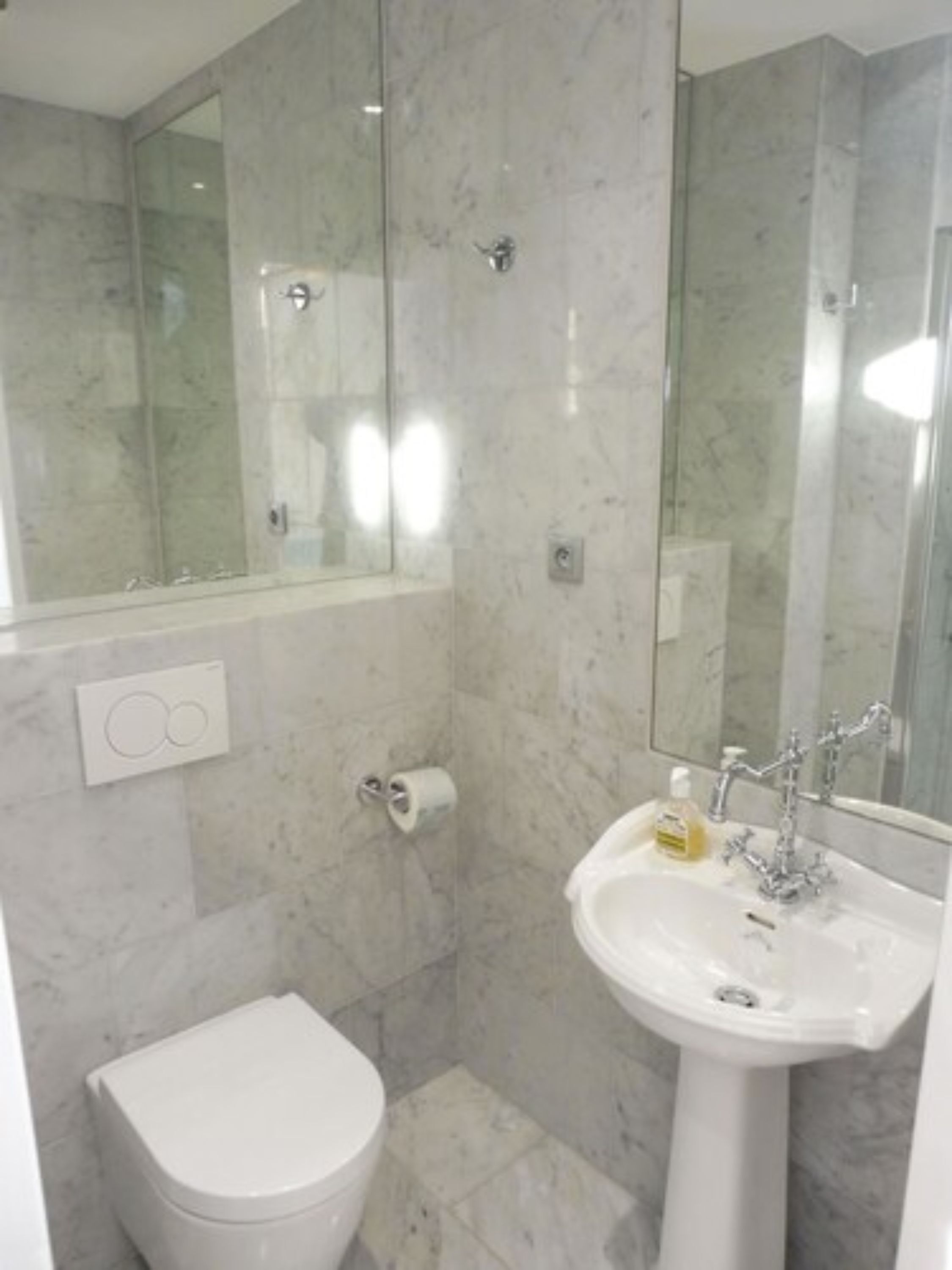 Een badkamer met toilet, wastafel en douche.