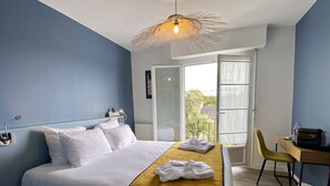 Une chambre d’hôtel avec un lit, un bureau et une fenêtre.