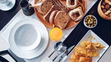 Desayuno con pan, bollería y una taza de café.