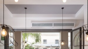 Un comedor con mesas y sillas, vista a una piscina y un balcón con mobiliario exterior.