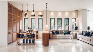 Un salón moderno y bien iluminado con un sofá, una mesa de centro y un mueble de madera con estantes.