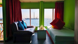 A room with a view of the sea, a sofa, a small table, and a bed. - Lareena Resort Koh Larn Pattaya (Koh Lan)