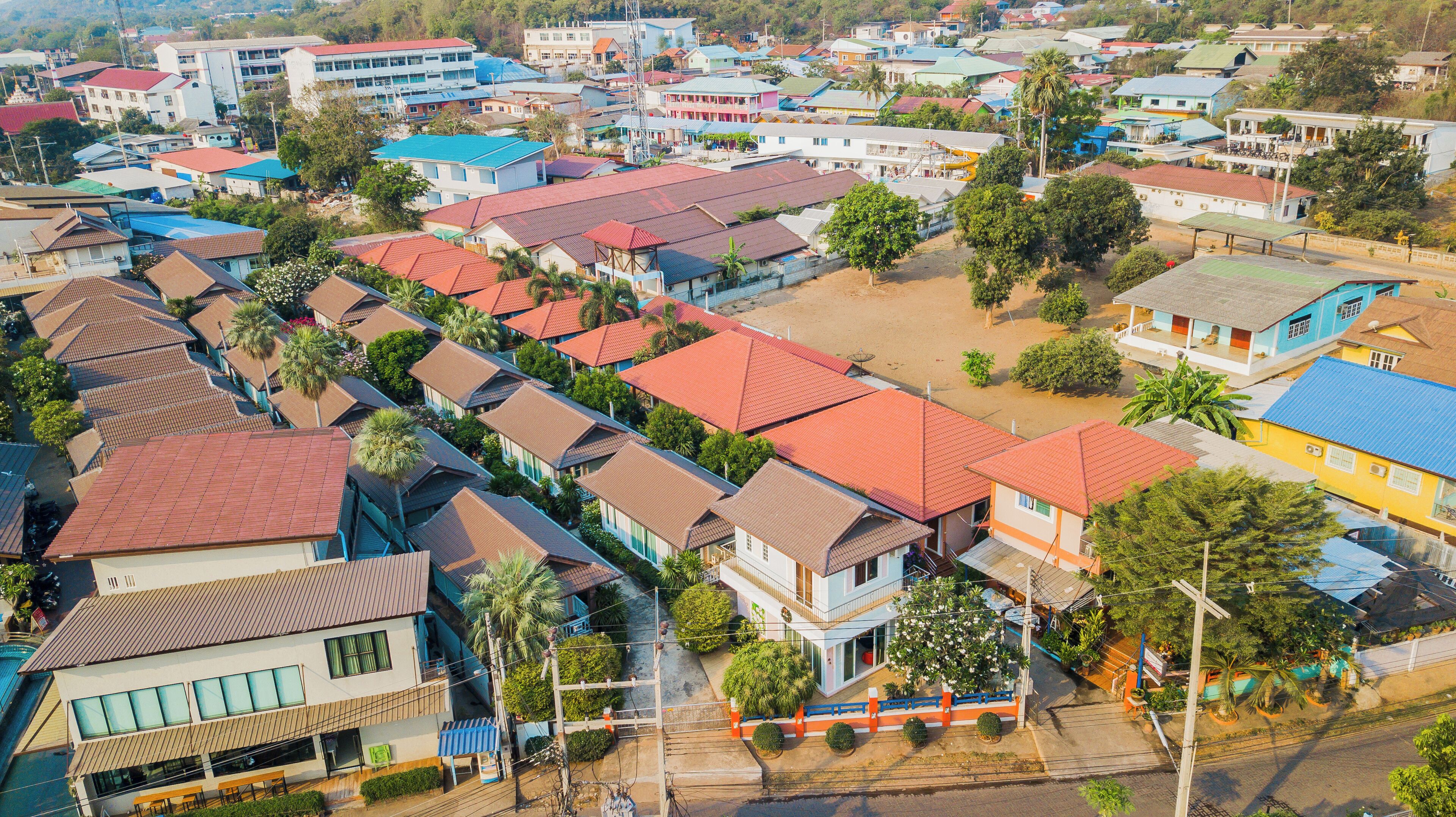 A residential area with closely packed houses, some with red roofs and others with blue.