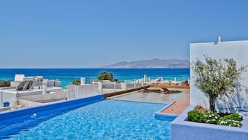 Una piscina al aire libre de temporada, sombrillas