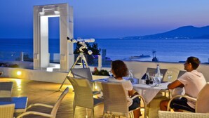 An outdoor dining area with a telescope, overlooking the sea. - Naxos Island Hotel (Naxos)