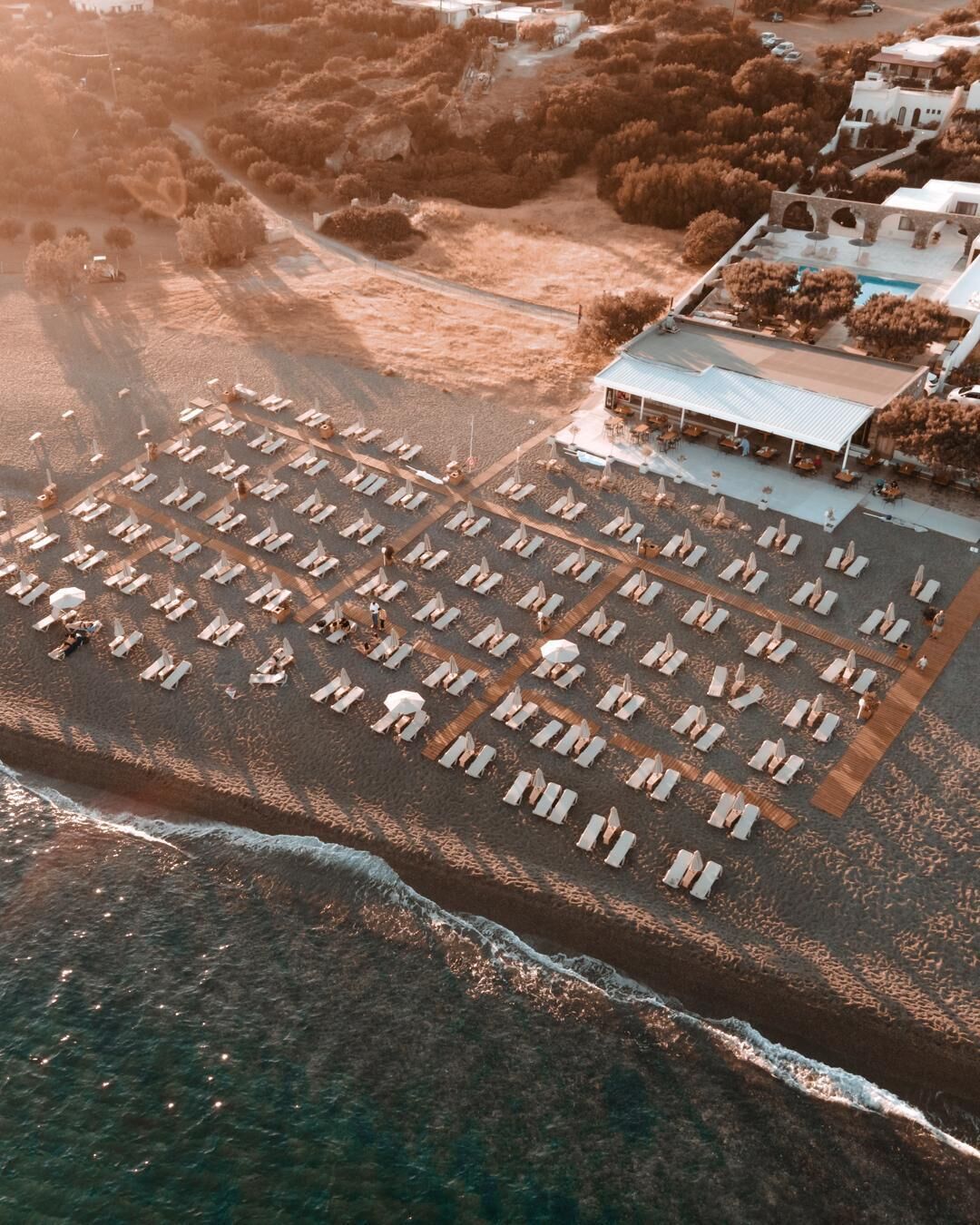 On the beach, black sand, sun loungers, beach umbrellas