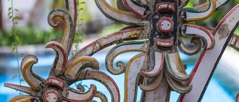 A decorative metal railing with intricate designs and a central circular element.