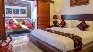 Un dormitorio luminoso con una cama grande, cabecera de madera y una mesita de noche con lámpara.
