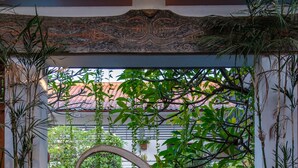 Un arco metálico decorativo que enmarca una piscina y una zona de estar al aire libre.