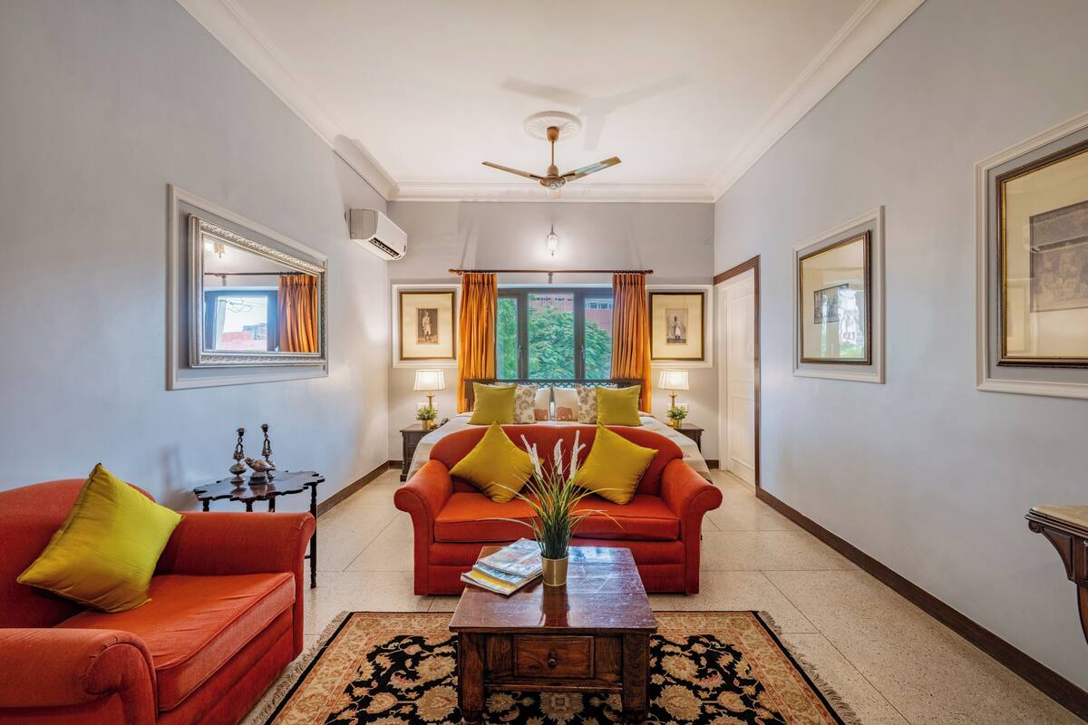 A living room with two red sofas, a coffee table, and a ceiling fan.