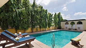 Een buitenzwembad en ligstoelen